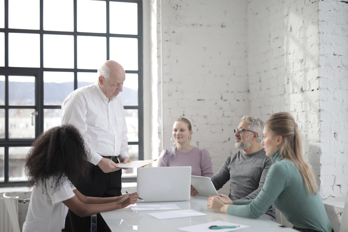 Serious man explaining information to coworkers in office
