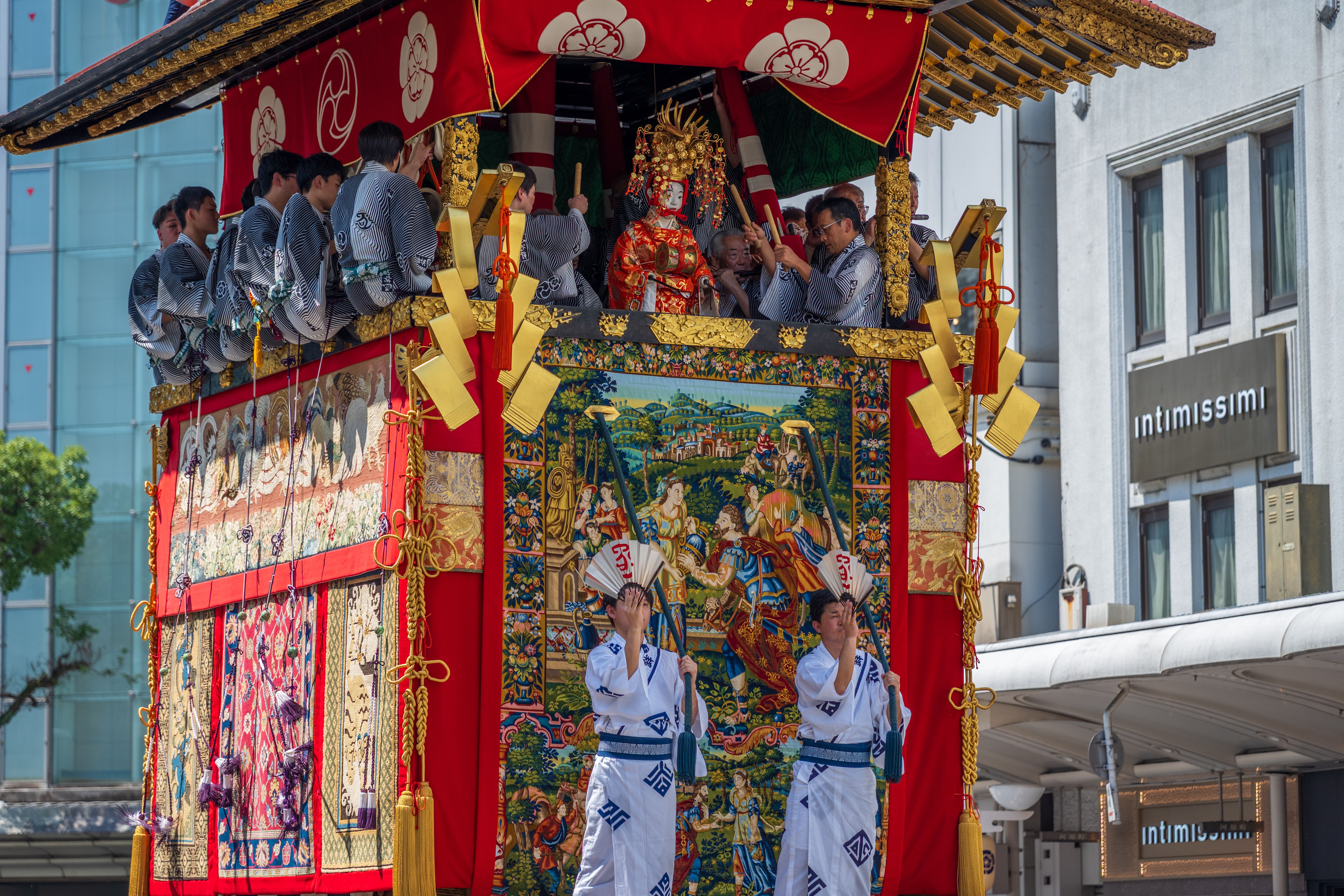 京都の有名なパレードで、伝統衣装を身にまとった人々が乗った、活気に満ちた山車。