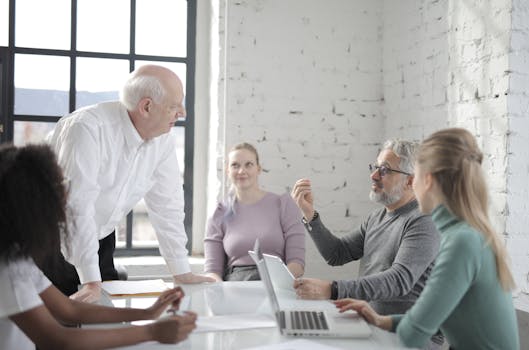 Diverse group of professionals engaged in discussion in a modern office setting.