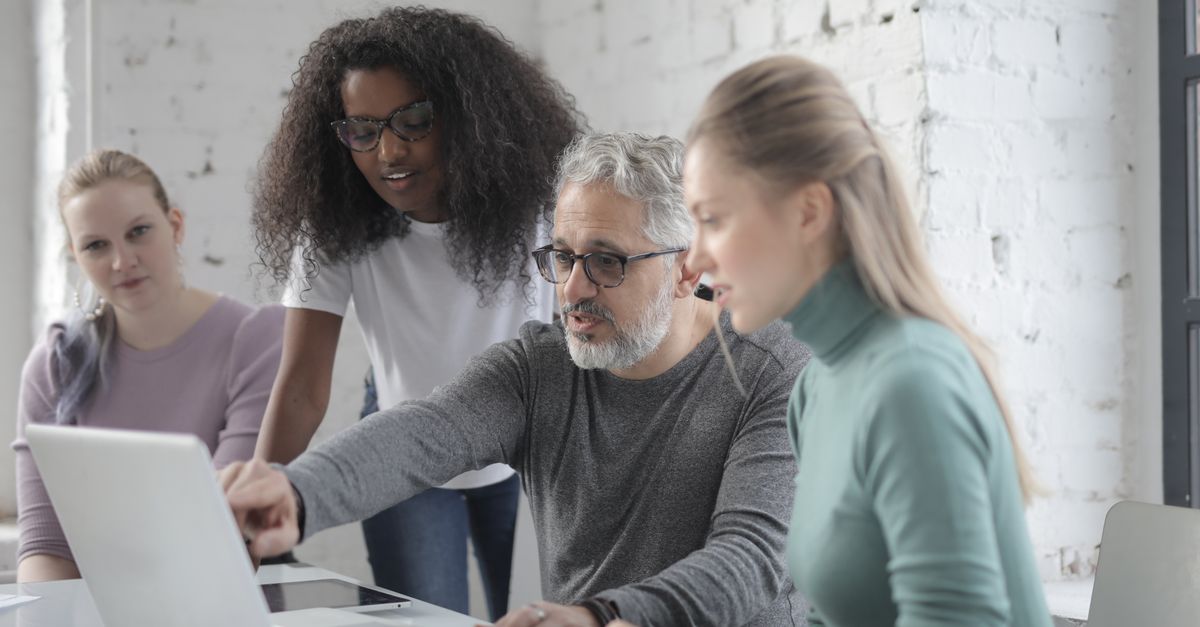 diverse group of health professionals collaborating on a laptop