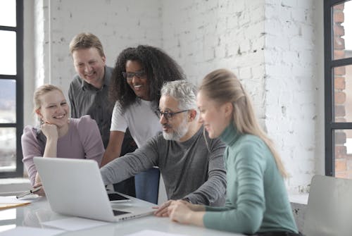 Smiling group of colleagues discussing project in office