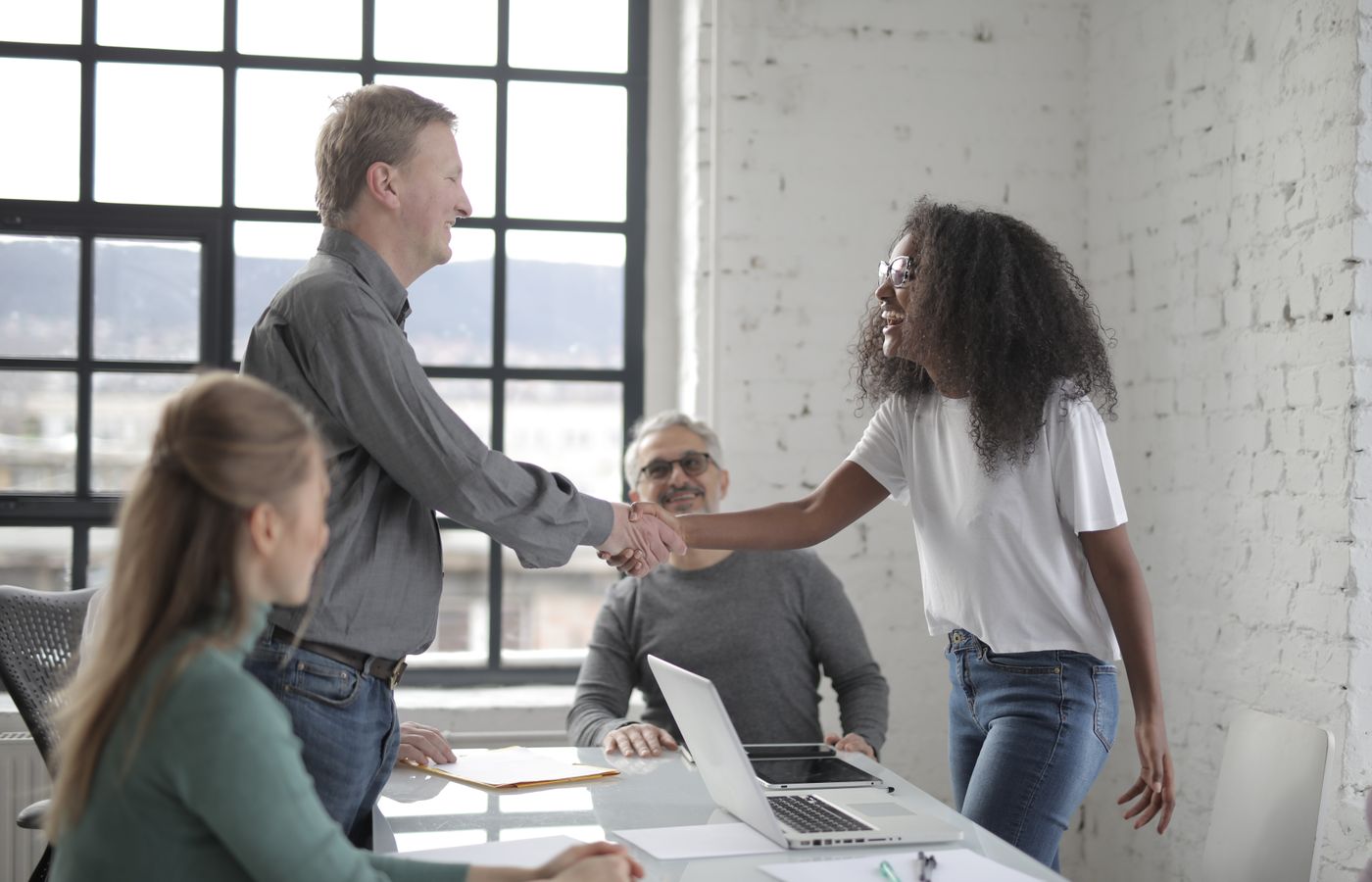 A diverse group of professionals collaborating in a bright, modern office setting during the day.