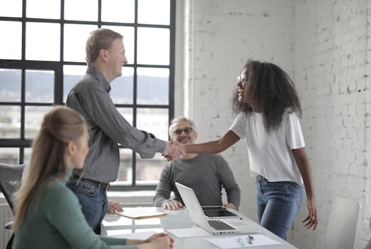 A diverse group of professionals collaborating in a bright, modern office setting during the day.