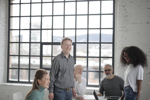 Free Smiling diverse colleagues discussing project in office Stock Photo