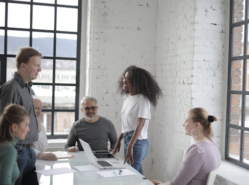 Free Cheerful diverse colleagues discussing project in office Stock Photo