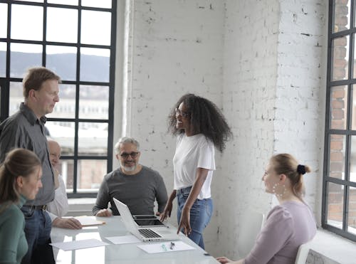 Cheerful diverse colleagues discussing project in office