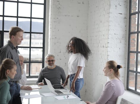 A diverse group of adults engaging in a collaborative meeting in a modern office environment.