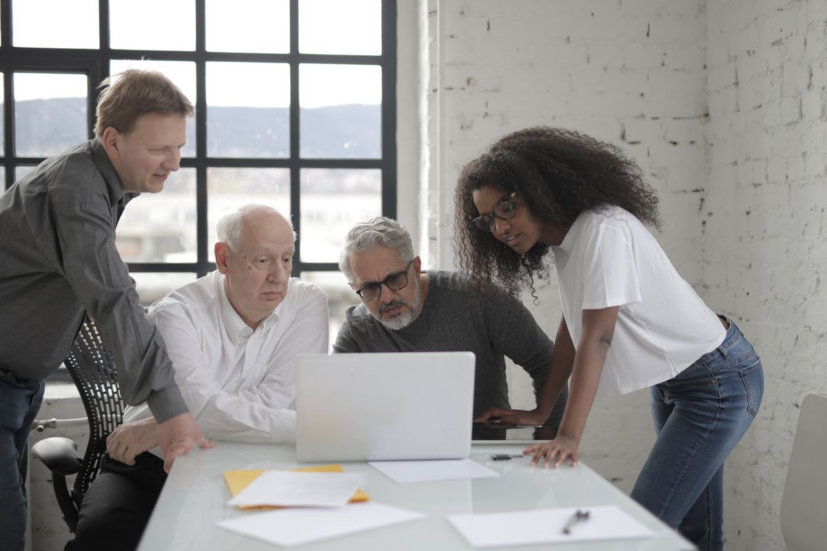 Business team collaborating around a laptop in a modern office
