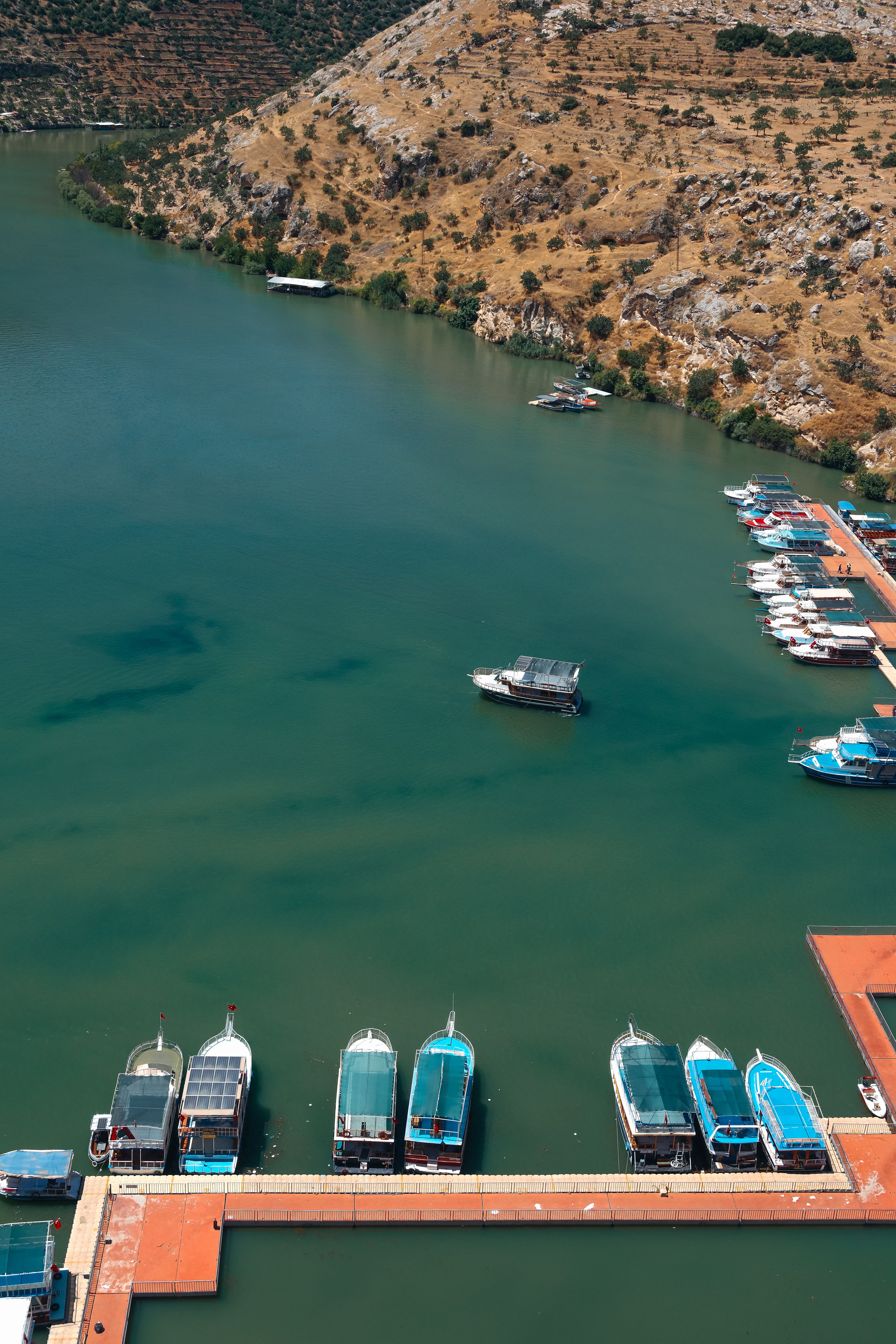 Scenic aerial view of boats docked on the turquoise waters of Halfeti, Türkiye.