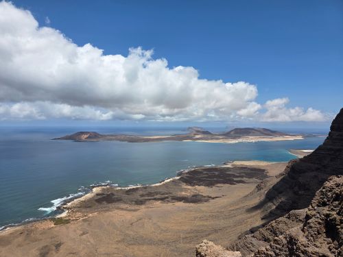 Free Dramatic aerial view of Lanzarote's volcanic coastlines with clear skies and ocean vistas. Stock Photo