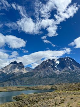 Scenic landscape of Torres del Paine with lakes and mountains under a vibrant blue sky.