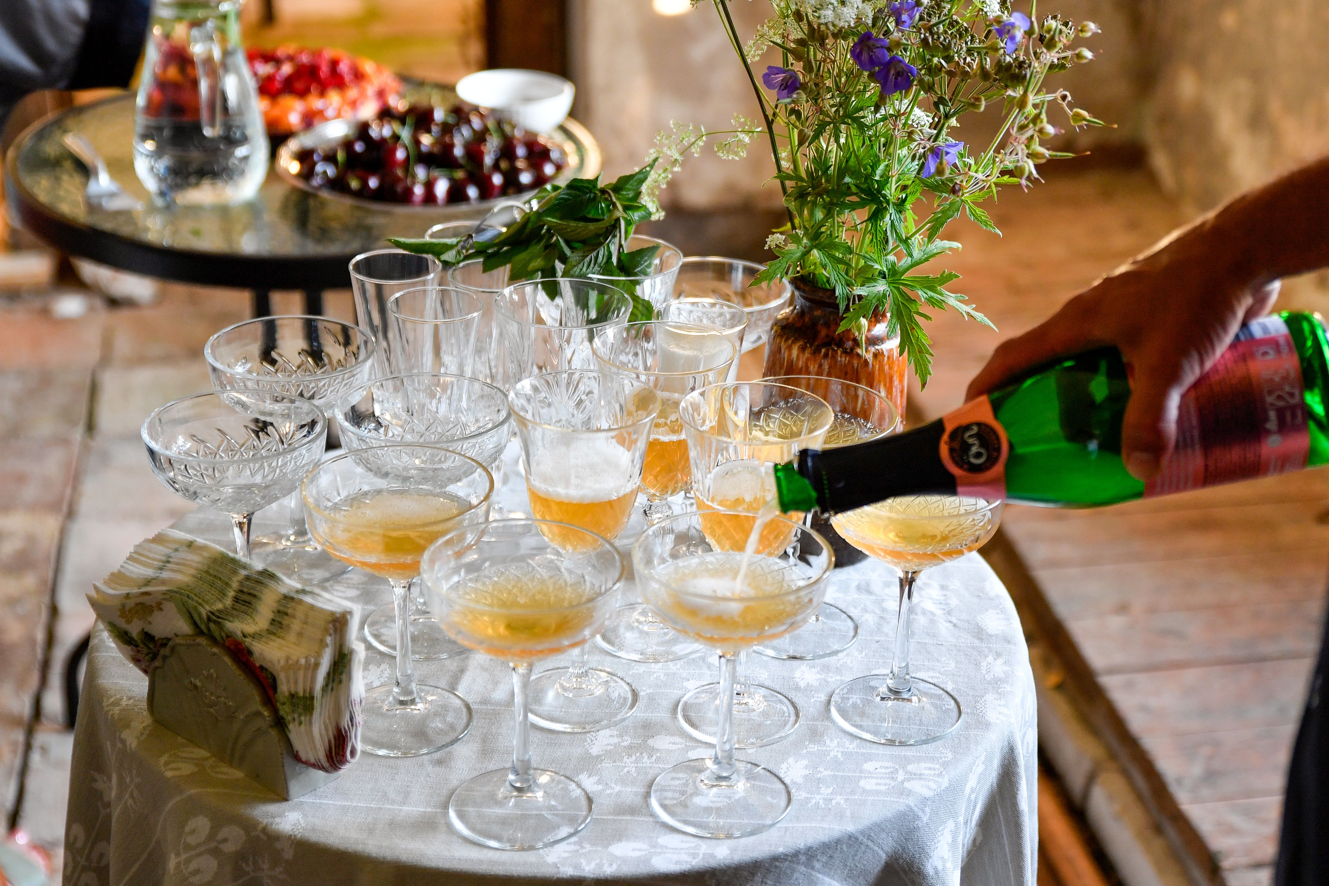 Sparkling beverages being poured into crystal glasses at a festive summer gathering in Estonia.