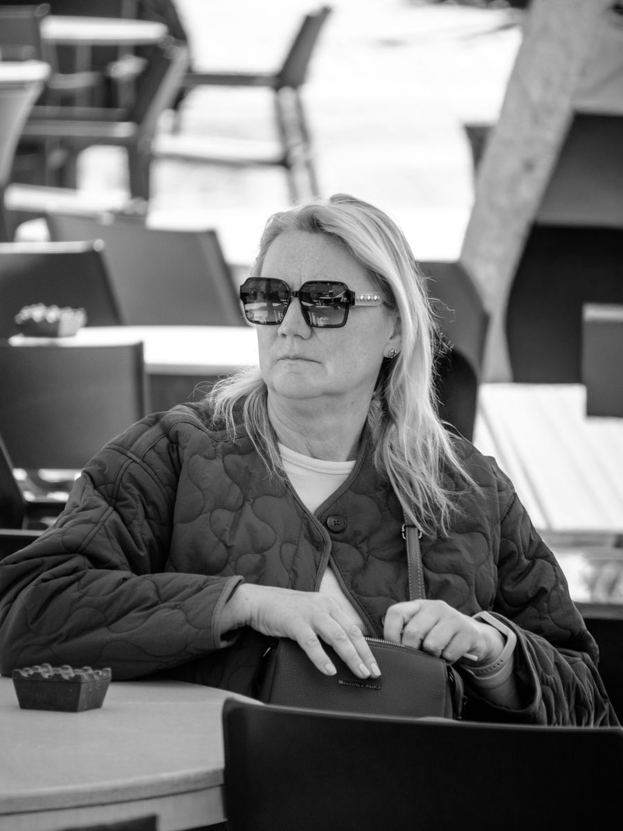 Woman in sunglasses seated outside a cafe by Ayşegül Aytören on Pexels