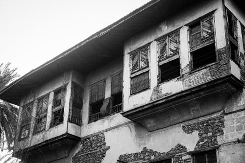 Free Black and white photo of an aged building with wooden shutters, depicting historical architecture. Stock Photo