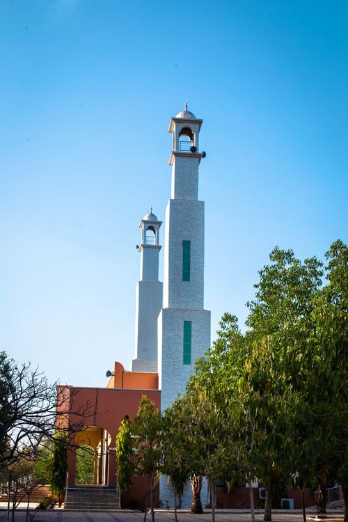Free Stunning view of mosque towers in Kano, Nigeria, surrounded by lush greenery under a clear blue sky. Stock Photo