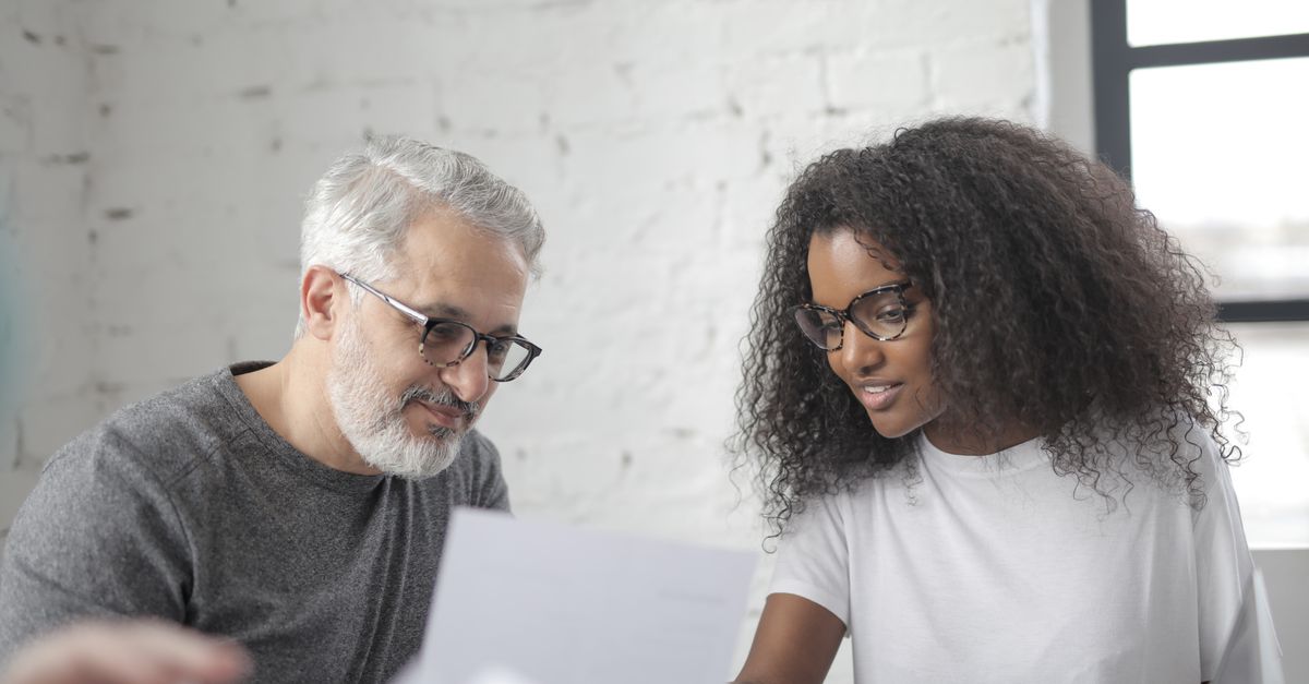 Senior man discussing business strategy with a young professional in an office