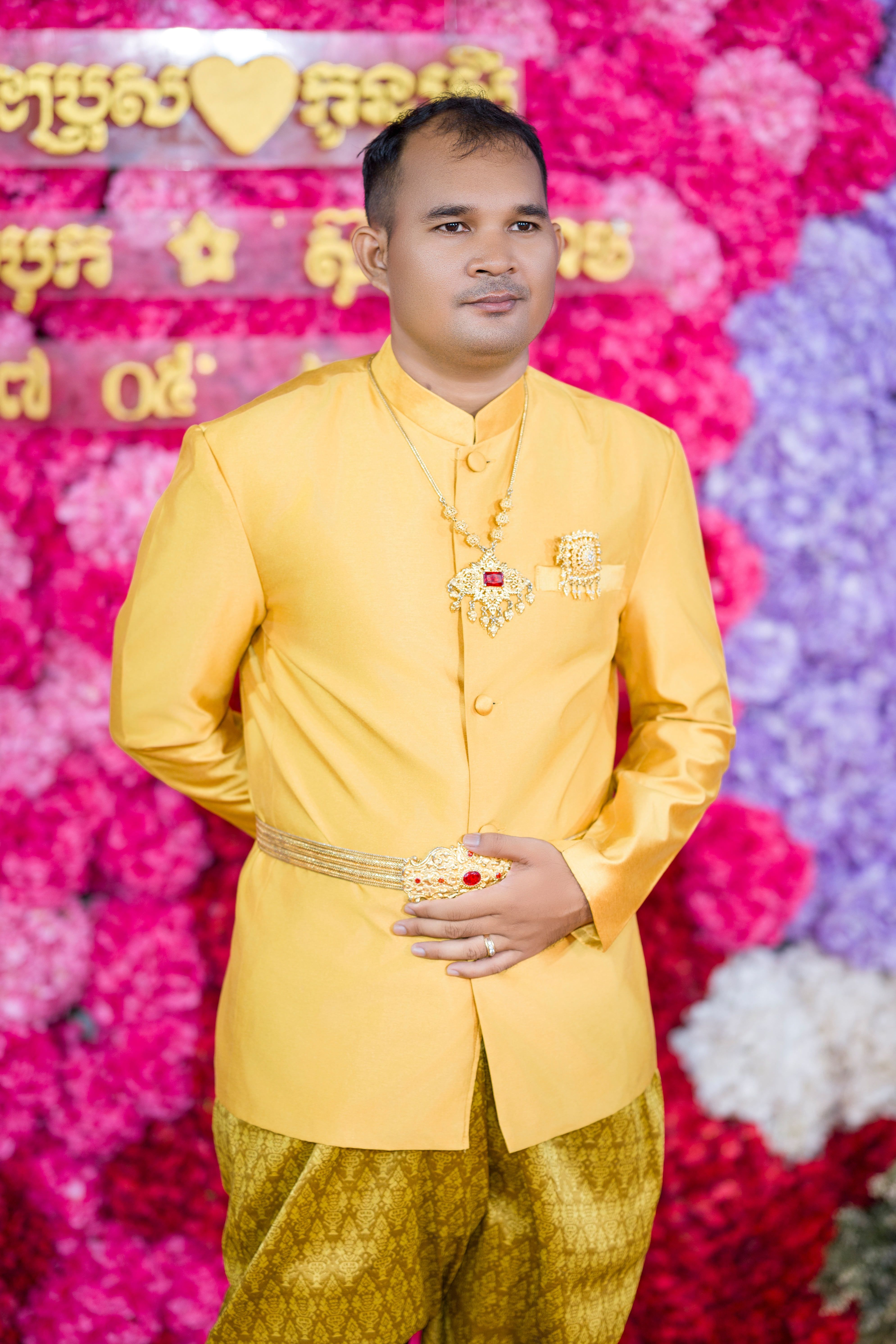 Traditional Khmer groom in vibrant attire at a Cambodian wedding ceremony.