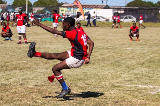 Dynamic photo of a youth rugby match with players in action, showcasing athletic skill.