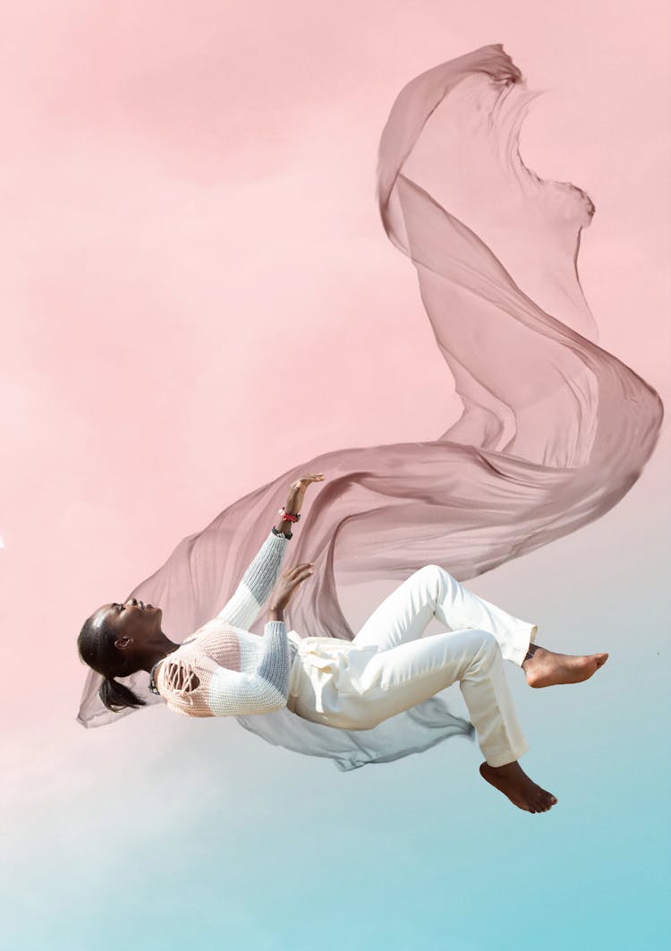 A Woman In White Pants Floating In The Air