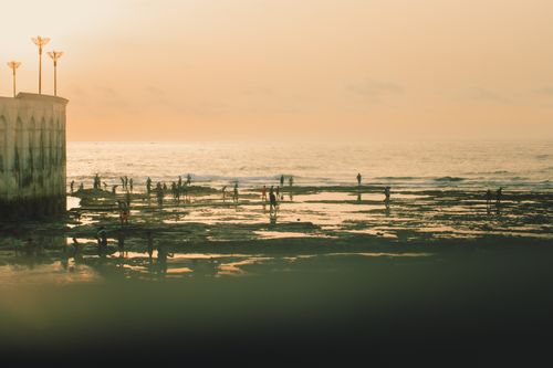 Free People enjoying a serene sunset at Casablanca beach with stunning ocean reflections. Stock Photo