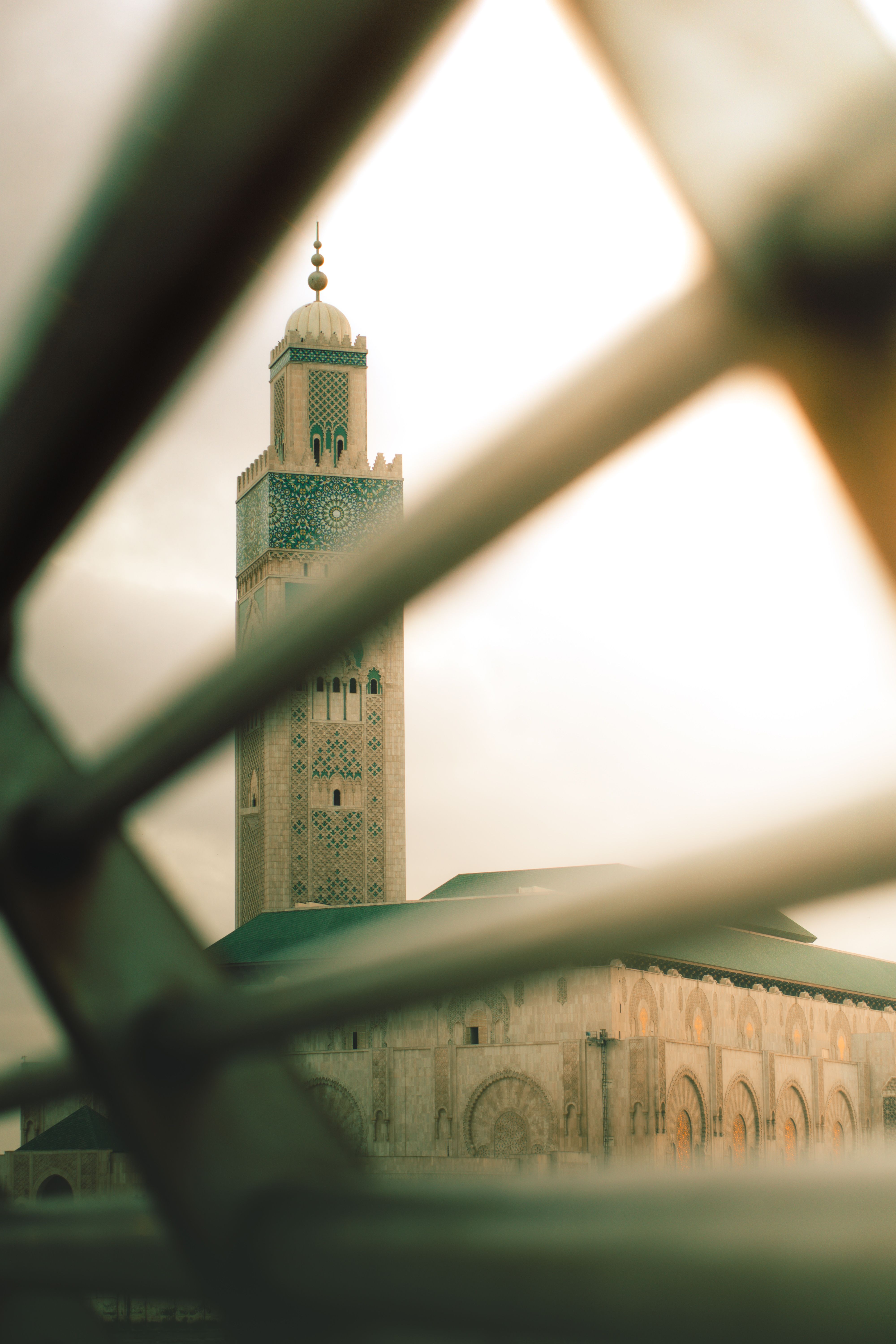 Stunning view of Hassan II Mosque minaret through the geometric frame at sunset in Casablanca, Morocco.