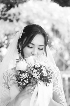 A beautiful bride holding a floral bouquet, captured in timeless black and white.
