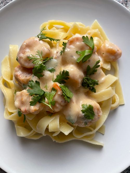 Free Delicious creamy shrimp pasta garnished with fresh parsley, served on a white plate. Stock Photo