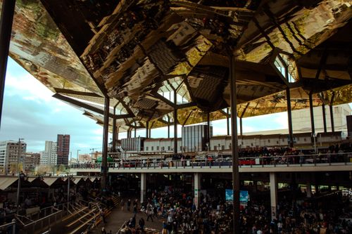 Free Urban market scene bustling with crowd under a striking reflective roof in a modern city. Stock Photo