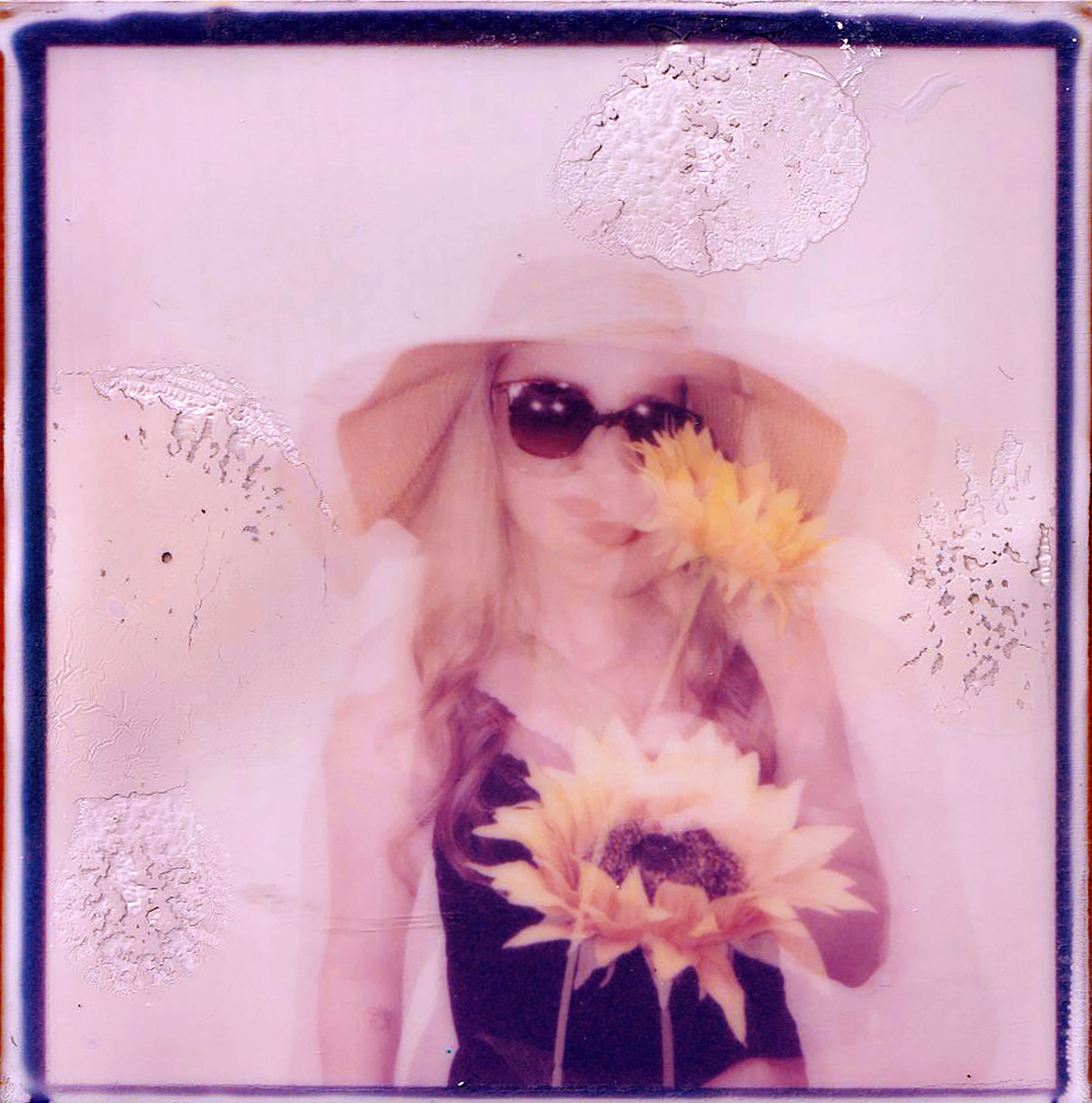 A dreamy double-exposure portrait of a woman holding sunflowers, exuding a vintage charm.
