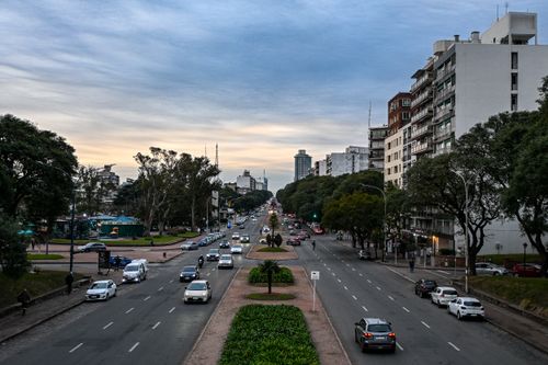 Free Scenic view of a busy street lined with buildings in Montevideo, Uruguay at dusk. Stock Photo