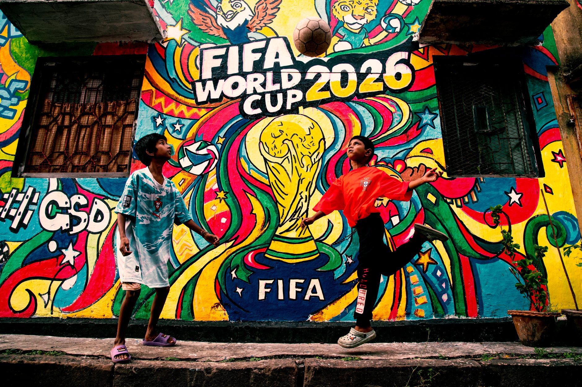 Vibrant mural of FIFA World Cup 2026 with kids playing soccer in the foreground.