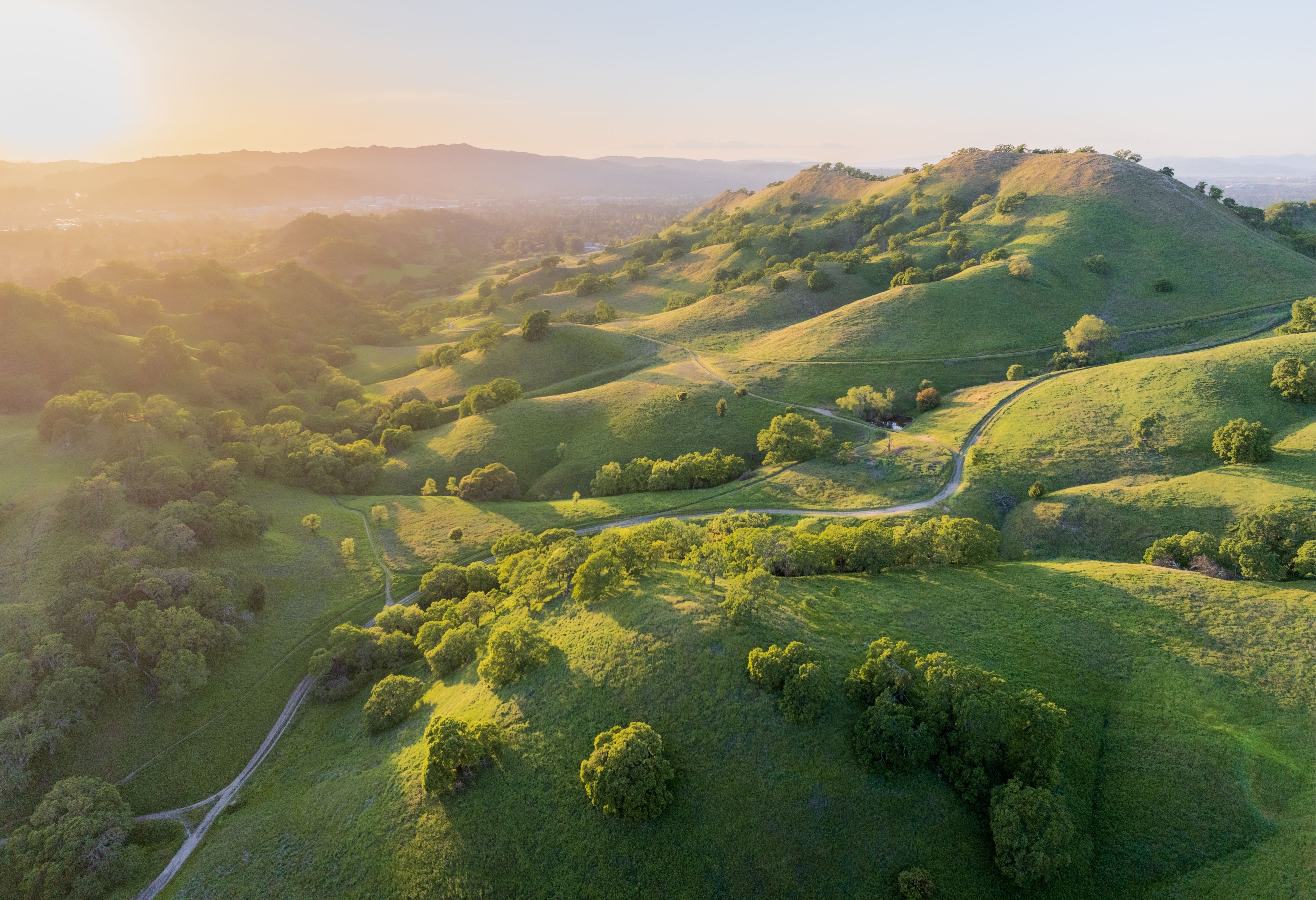 Aerial landscape of Altamont Pass, California showcasing rolling hills and sunrise.
