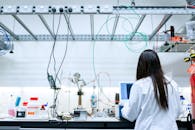 一位女科学家在现代实验室里，操作着各种设备进行研究