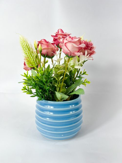 Free Vibrant floral arrangement with pink roses in a modern blue vase, perfect for home decor. Stock Photo