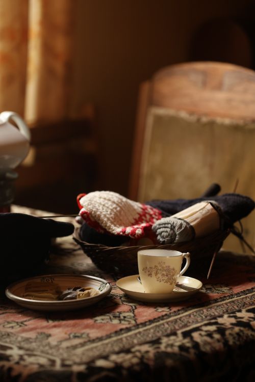Free Warm indoor scene with tea, knitting supplies, and soft lighting capturing a cozy afternoon. Stock Photo