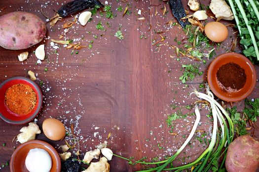 A vibrant collection of fresh ingredients and spices on a wooden table with ample copyspace.