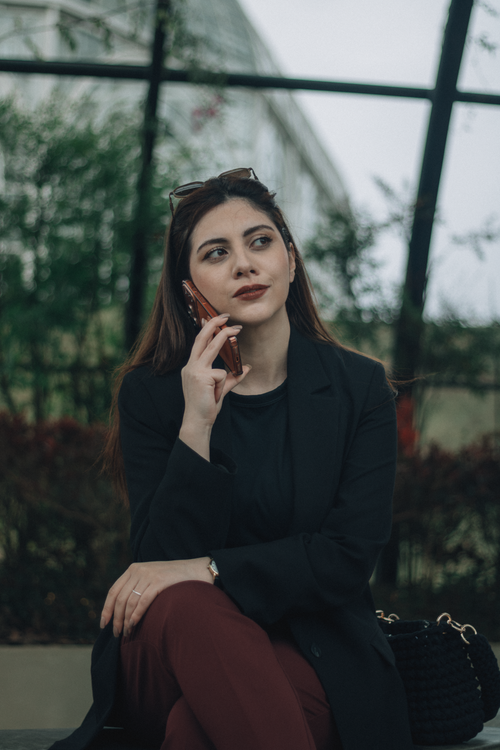 Free Young professional woman talking on her phone in an outdoor setting. Stock Photo