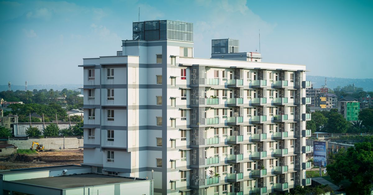 Contemporary multi-storey building with urban skyline in the background, showcasing modern architecture.