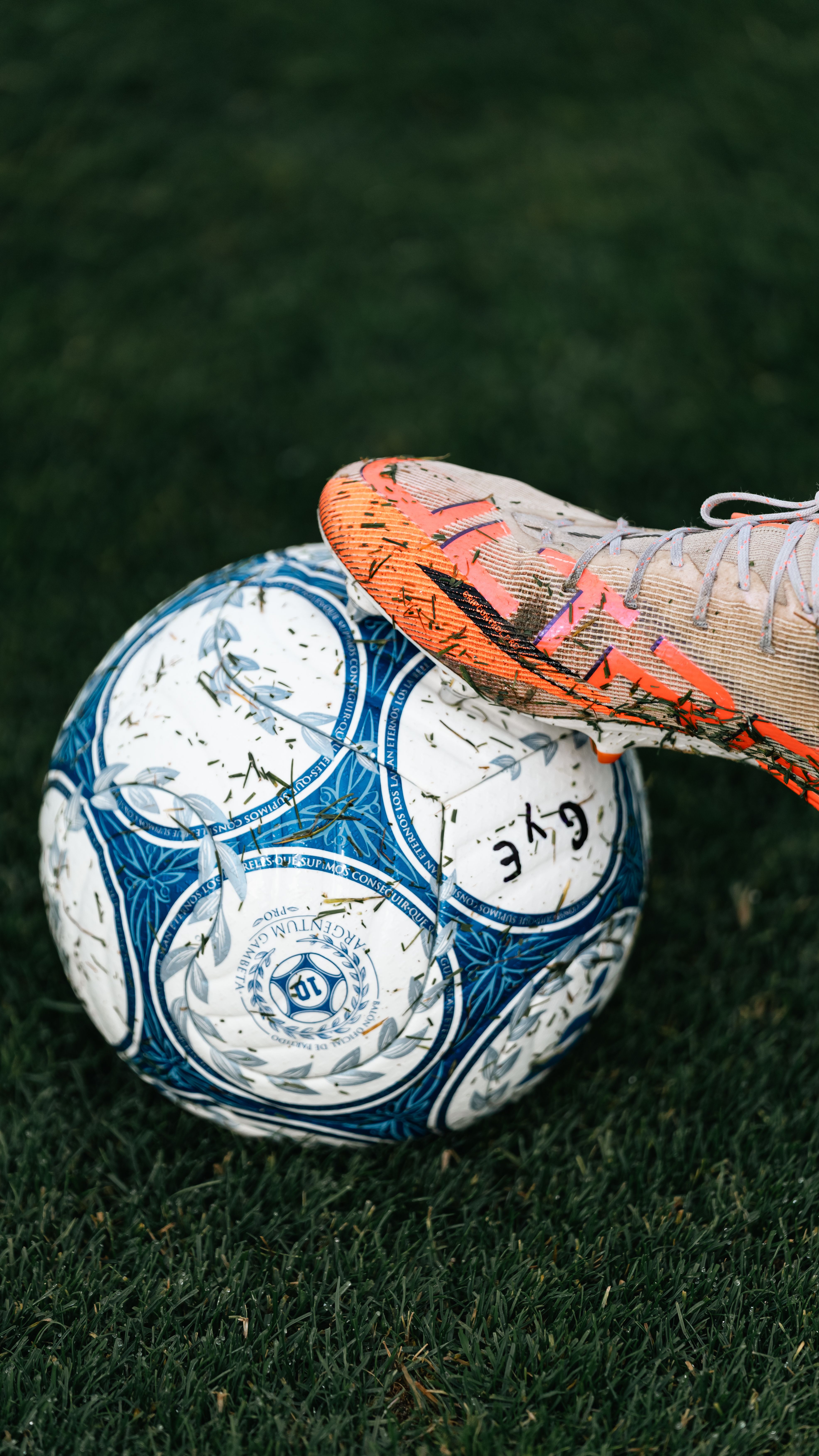 Close-up of a soccer ball with cleats on a green field, perfect for sports concepts.