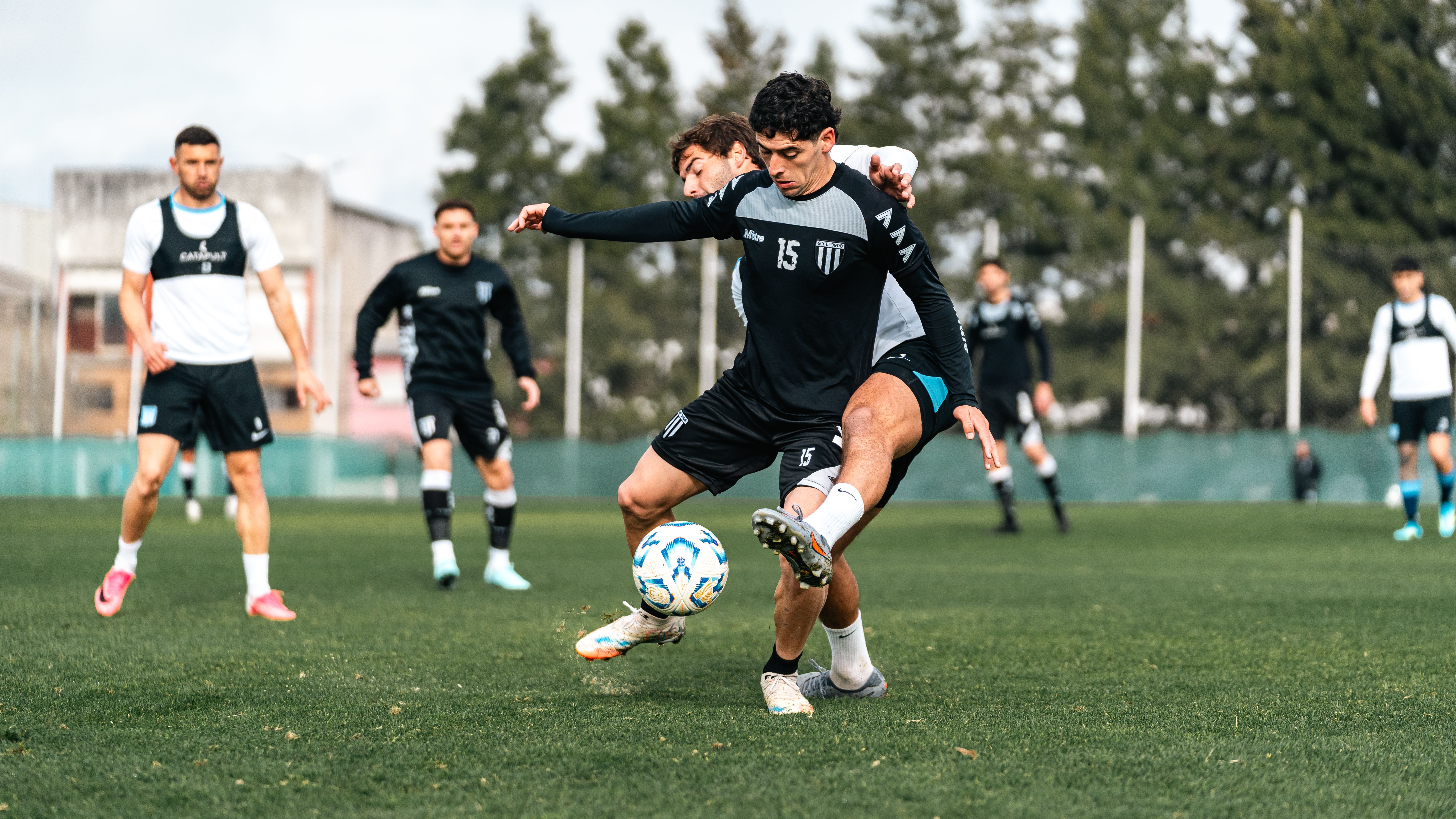 Competitive soccer match with focused players in action on a green field, showcasing skills and teamwork.