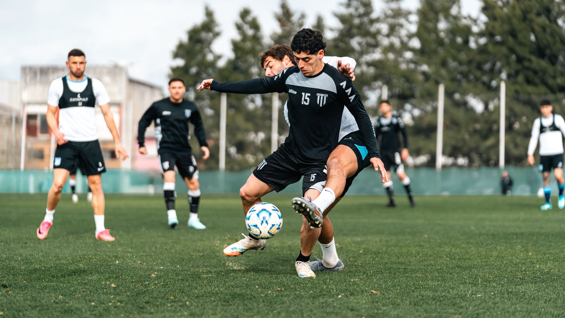 Competitive soccer match with focused players in action on a green field, showcasing skills and teamwork.
