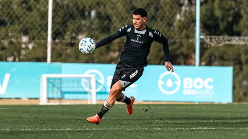 Free A soccer player energetically dribbles during practice, showcasing athletic skill. Stock Photo