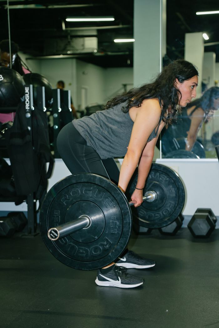 A woman deadlifting on her own in a gym