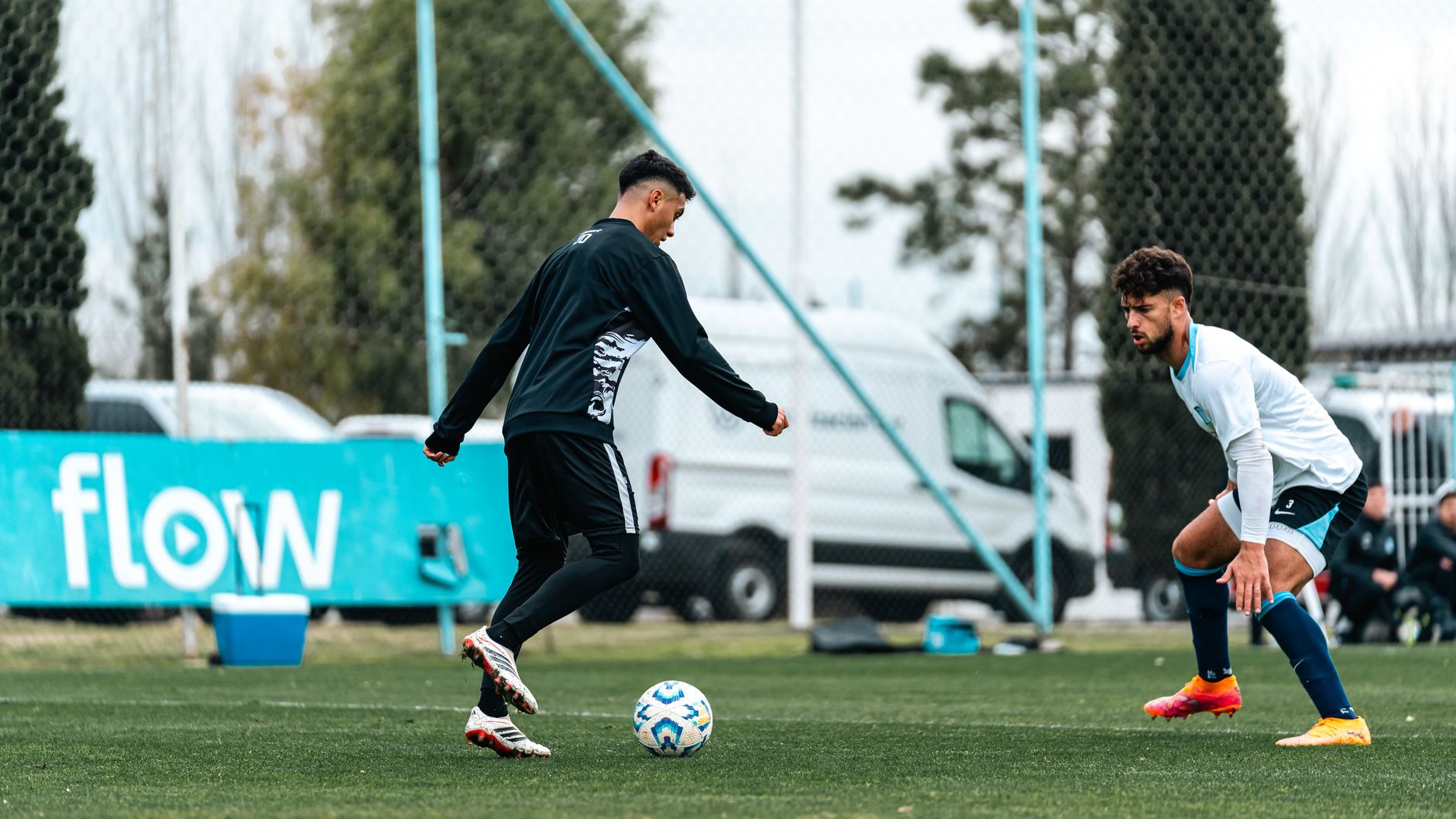 Two players in action during a competitive outdoor soccer match on a grassy field.