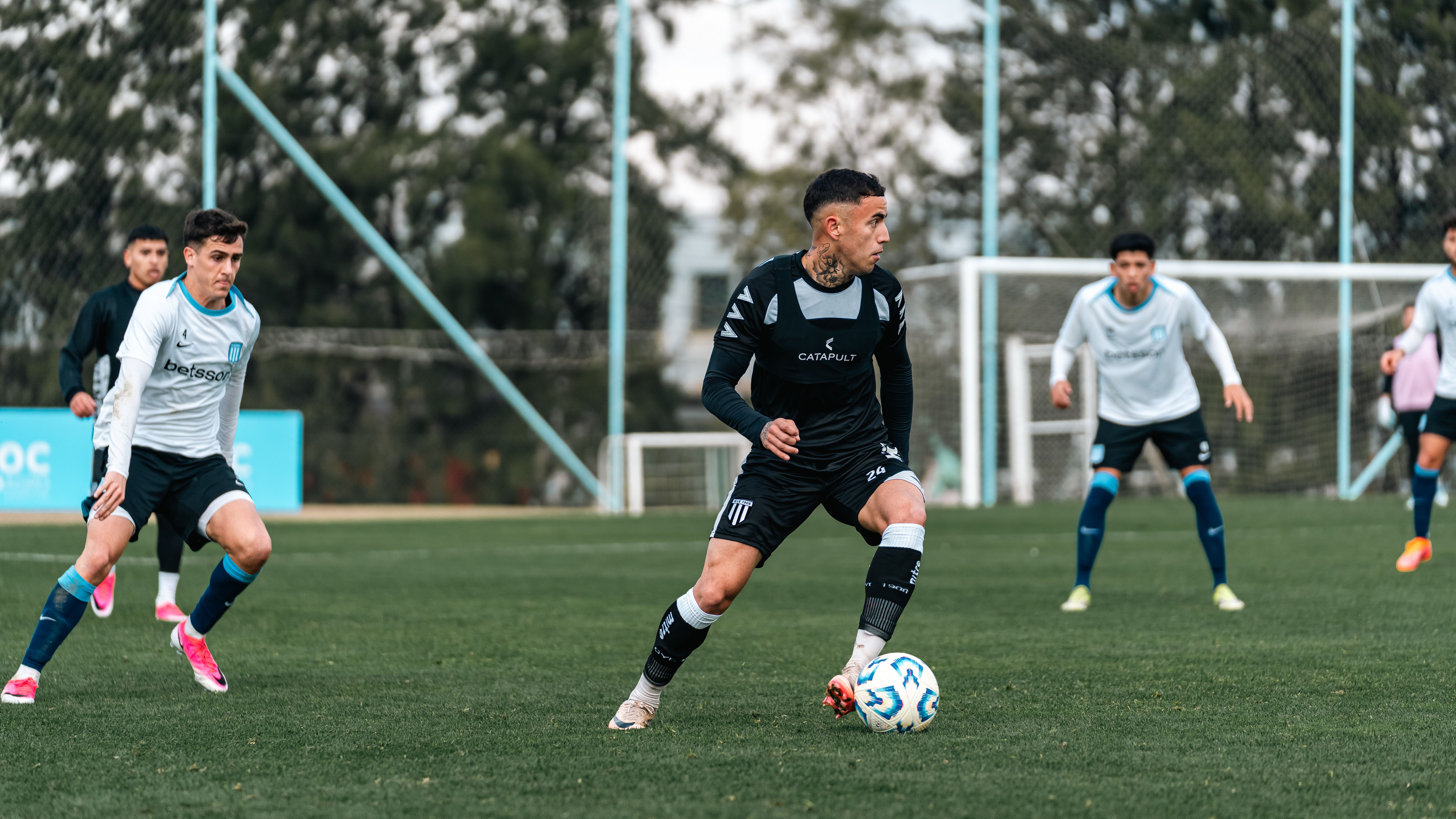 Players compete in an intense soccer match on a well-maintained grass field.