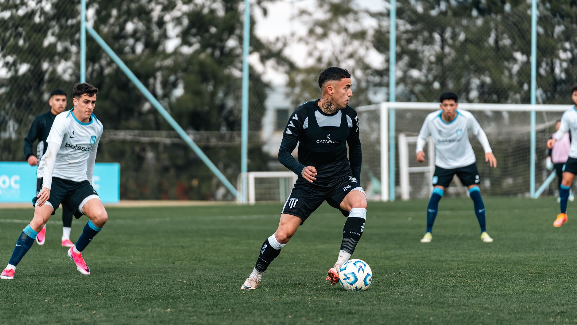 Players compete in an intense soccer match on a well-maintained grass field.