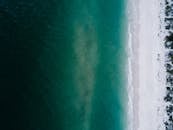 航拍照片令人惊叹，捕捉到了宁静的海滩，清澈的碧绿海水与白沙融为一体