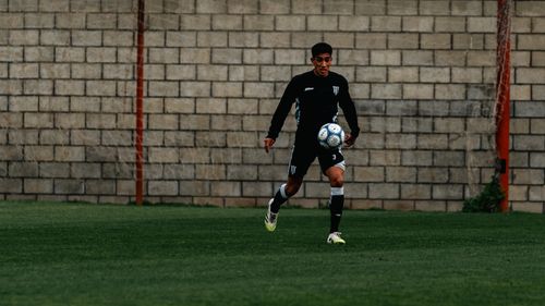 Free A soccer player in black uniform dribbles the ball during daytime practice. Stock Photo