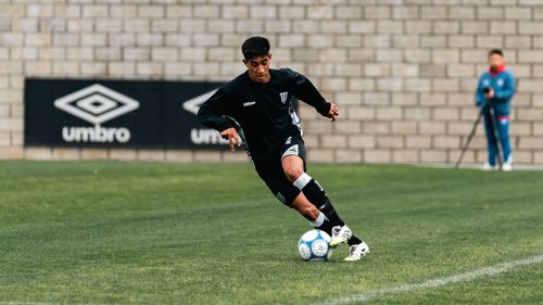 Free A young male soccer player dribbling a ball during a game outdoors. Stock Photo