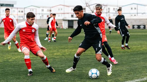 Free Players compete in an engaging soccer match displaying skill and teamwork. Stock Photo